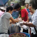 Sama-samang kumukuha ng pananghaliang isda, giniling, at ensalada ang mga unyonista’t boluntaryo